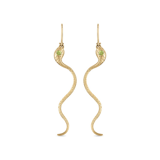 A pair of 14k gold snake earrings with engraved scales, milgrain bezel set yellow green sapphire head stones and diamond eye stones. The closed shepherd hook earrings each have a snake suspended by a ring in its mouth and long tail curving down.