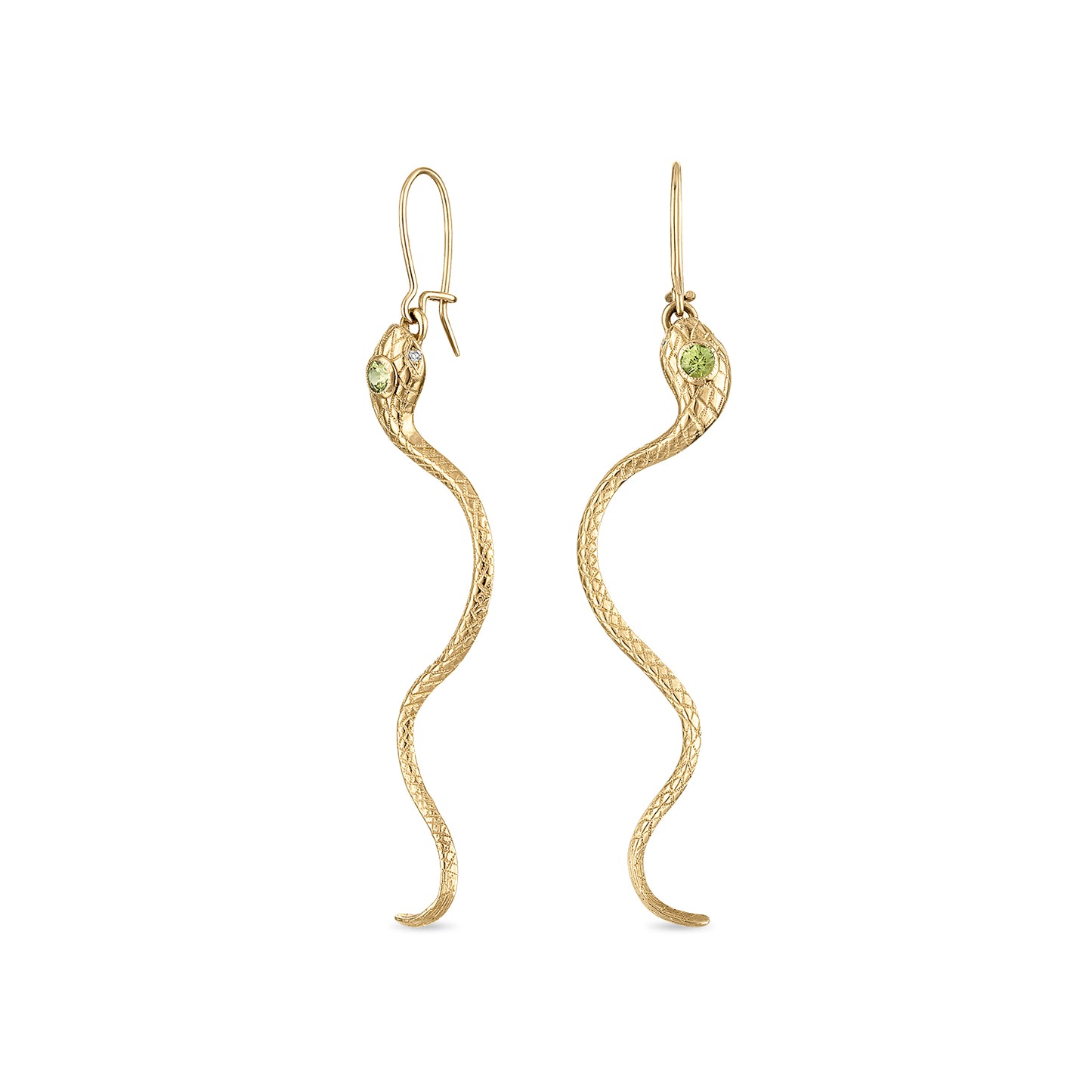 A pair of 14k gold snake earrings with engraved scales, milgrain bezel set yellow green sapphire head stones and diamond eye stones. The closed shepherd hook earrings each have a snake suspended by a ring in its mouth and long tail curving down.