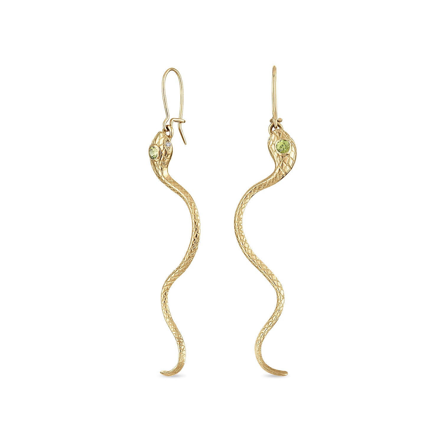 A pair of 14k gold snake earrings with engraved scales, milgrain bezel set yellow green sapphire head stones and diamond eye stones. The closed shepherd hook earrings each have a snake suspended by a ring in its mouth and long tail curving down.
