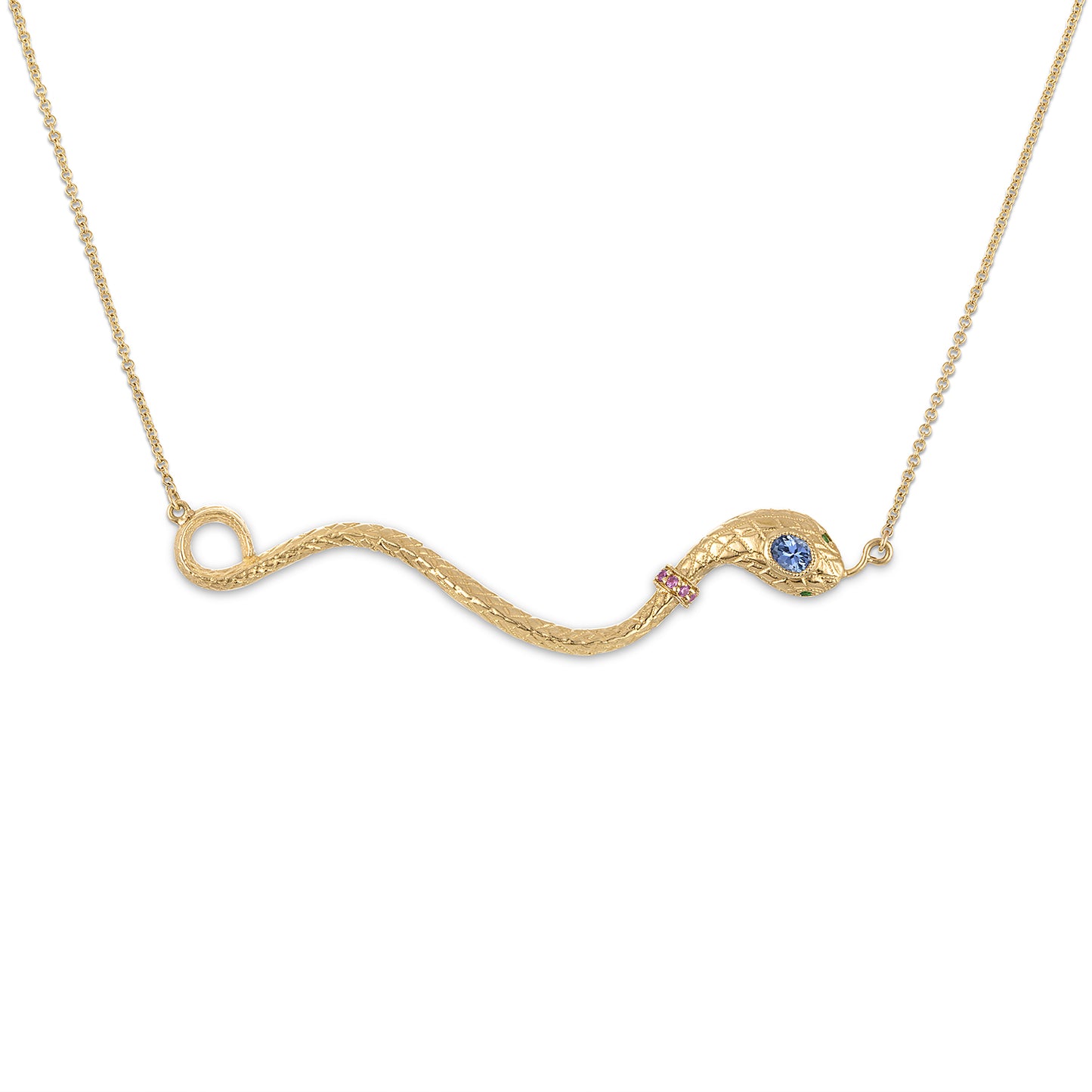 14k yellow gold snake necklace centering a horizontal curving snake pendant suspended on a 16" gold chain by its tail and tongue. Snake wears a pink ruby collar and has a violet blue sapphire oval cut head stone and round green eye stones.