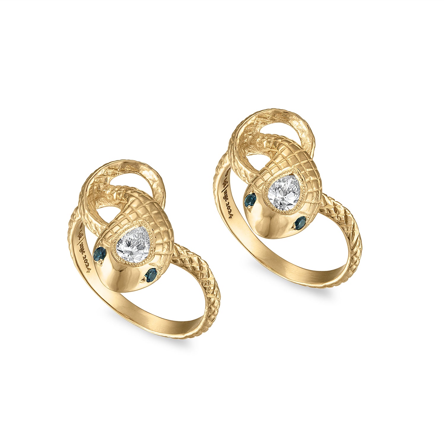 Two 14k gold snake rings with engraved scales, milgrain bezel set pear shaped diamond center stones and teal sapphire eye stones.
